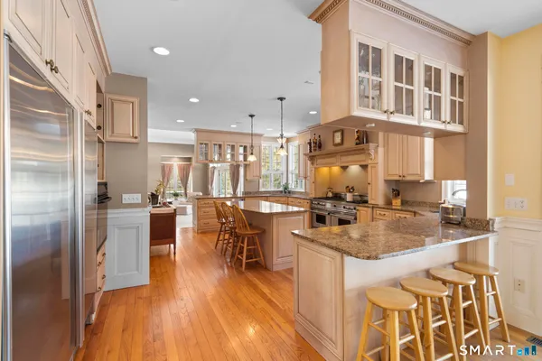 a kitchen with a refrigerator and a view of living room