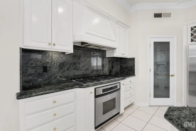 a kitchen with granite countertop a sink a stove and granite counter tops