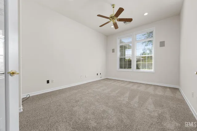 an empty room with fan and windows