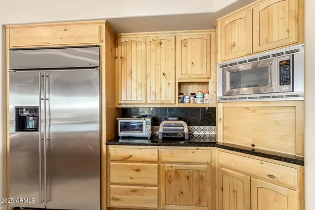 a kitchen with stainless steel appliances granite countertop a refrigerator a stove and a cabinets