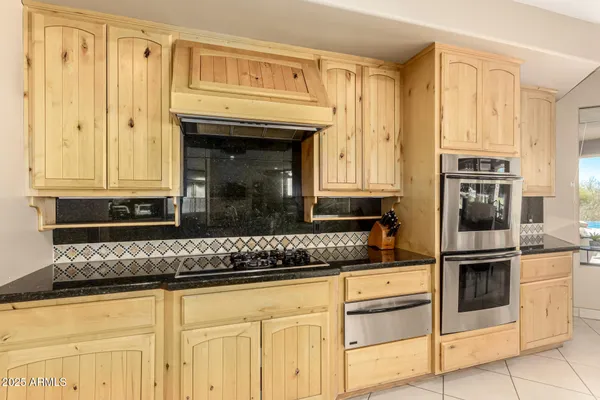 a kitchen with granite countertop white cabinets and stainless steel appliances
