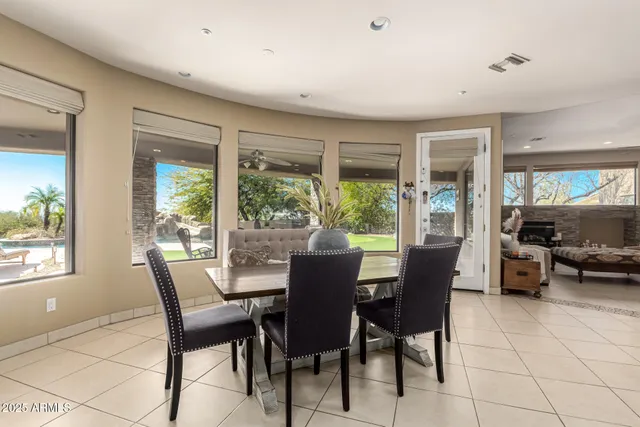 a dining room with furniture and large windows