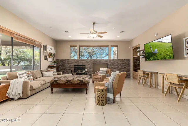 a living room with furniture a flat screen tv and a large window