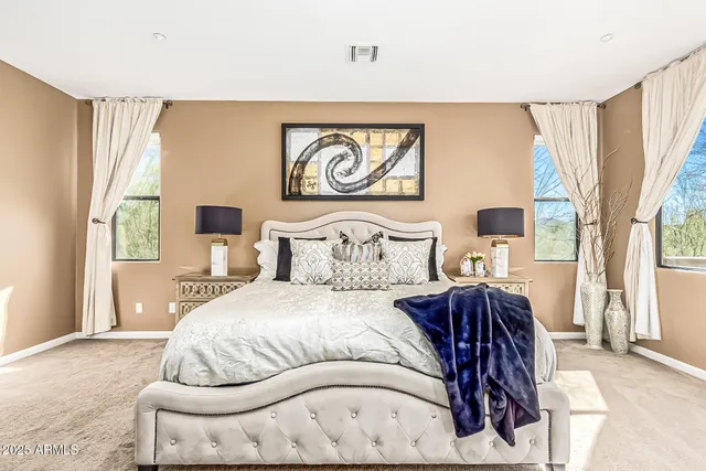 a bedroom with a bed and a large window