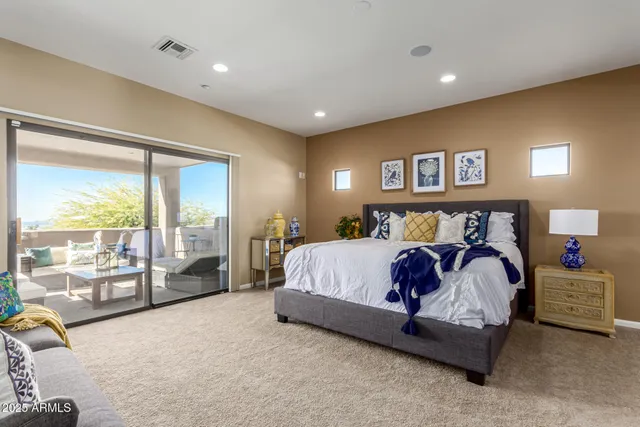 a spacious bedroom with a bed and glass window