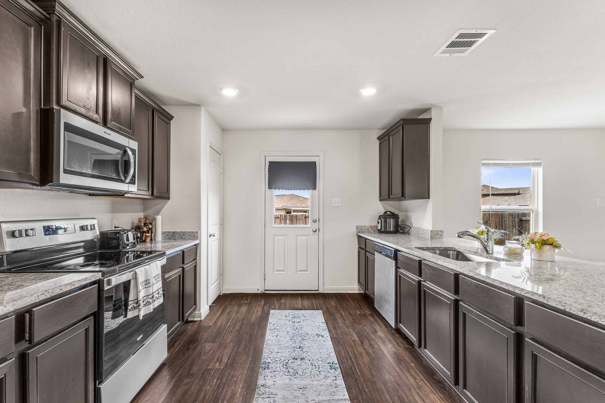 304 Hyacinth Way, Unit #7K Jarrell, TX 76537 - Photo 8 of 26 A well-appointed kitchen showcasing elegant dark cabinetry and ample counter space.