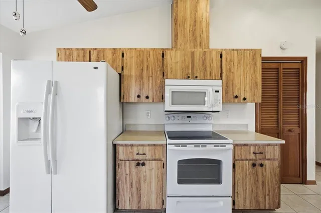 a kitchen with a stove top oven and refrigerator