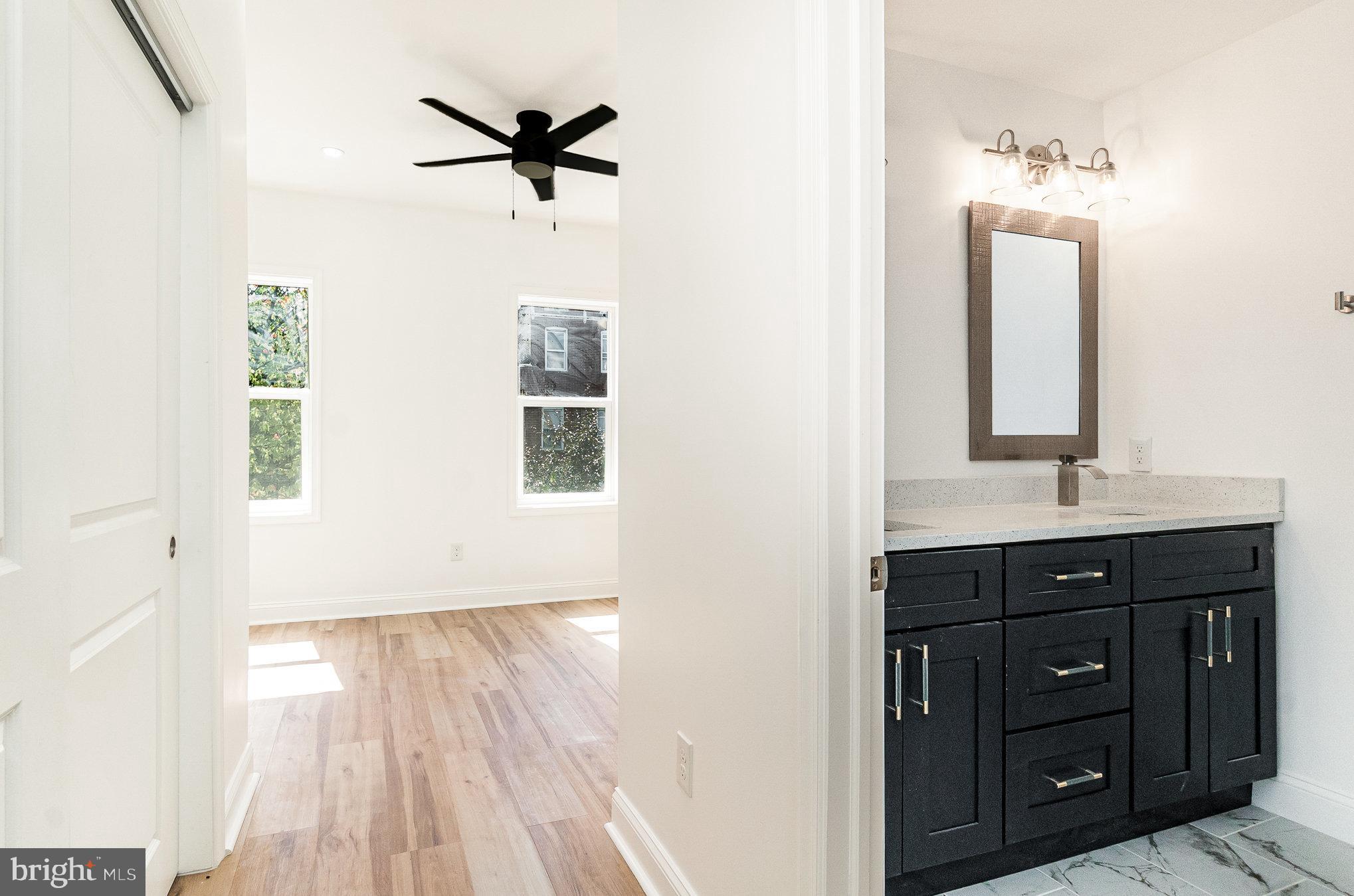 727 North Collington Avenue Baltimore, MD 21205 - Photo 12 of 25 a bathroom with a sink a mirror and a shower
