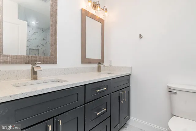 a bathroom with a sink a toilet and mirror