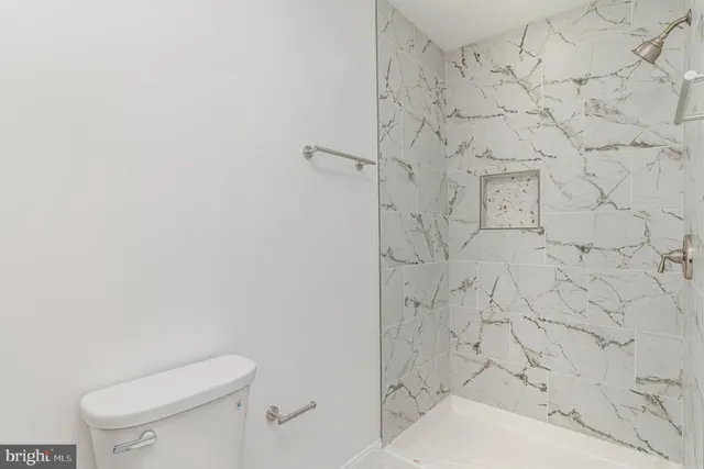 a white toilet sitting next to a shower
