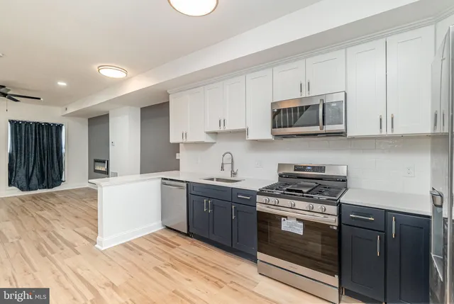 a kitchen with stainless steel appliances granite countertop a stove microwave and cabinets