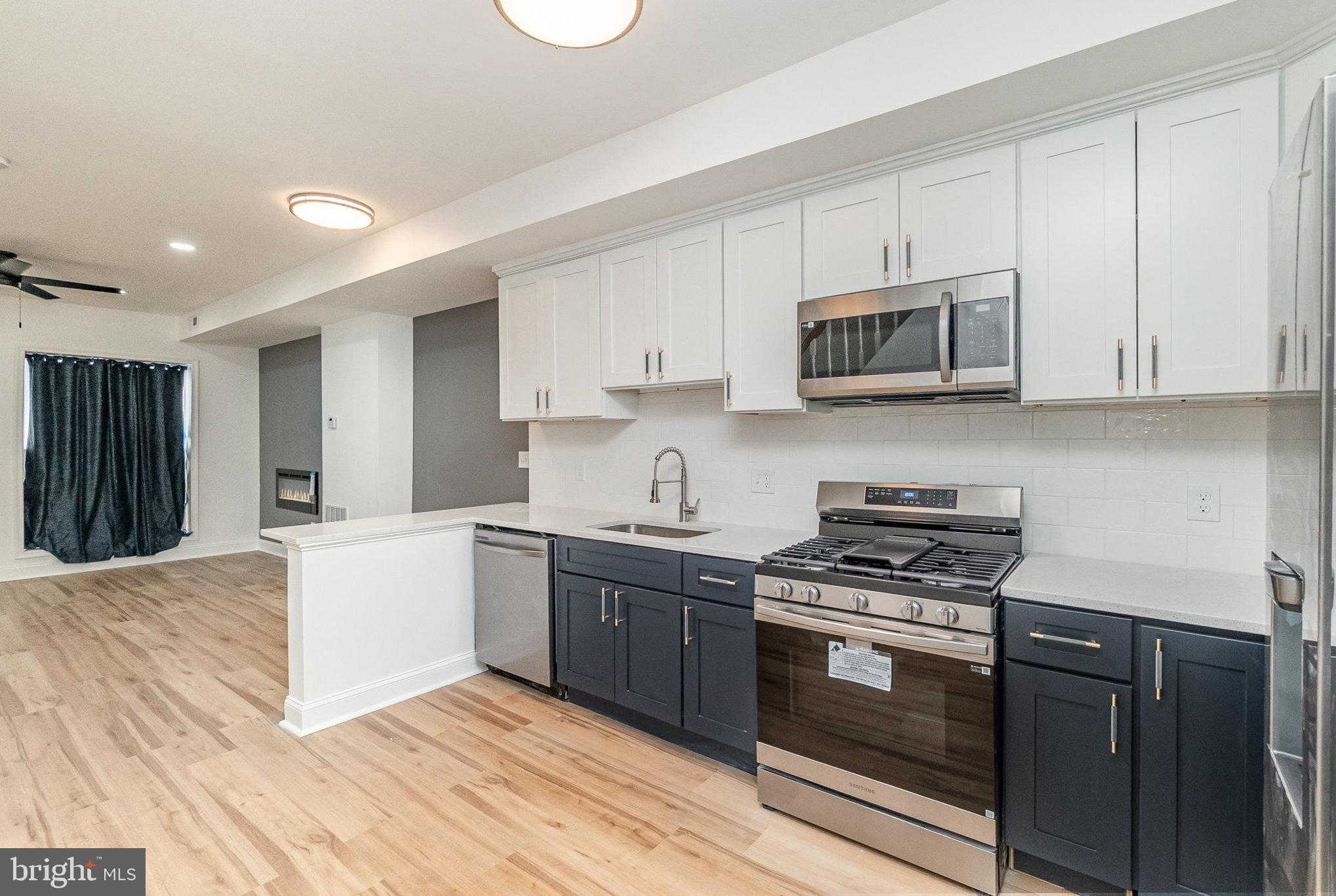 727 North Collington Avenue Baltimore, MD 21205 - Photo 5 of 25 a kitchen with stainless steel appliances granite countertop a stove microwave and cabinets
