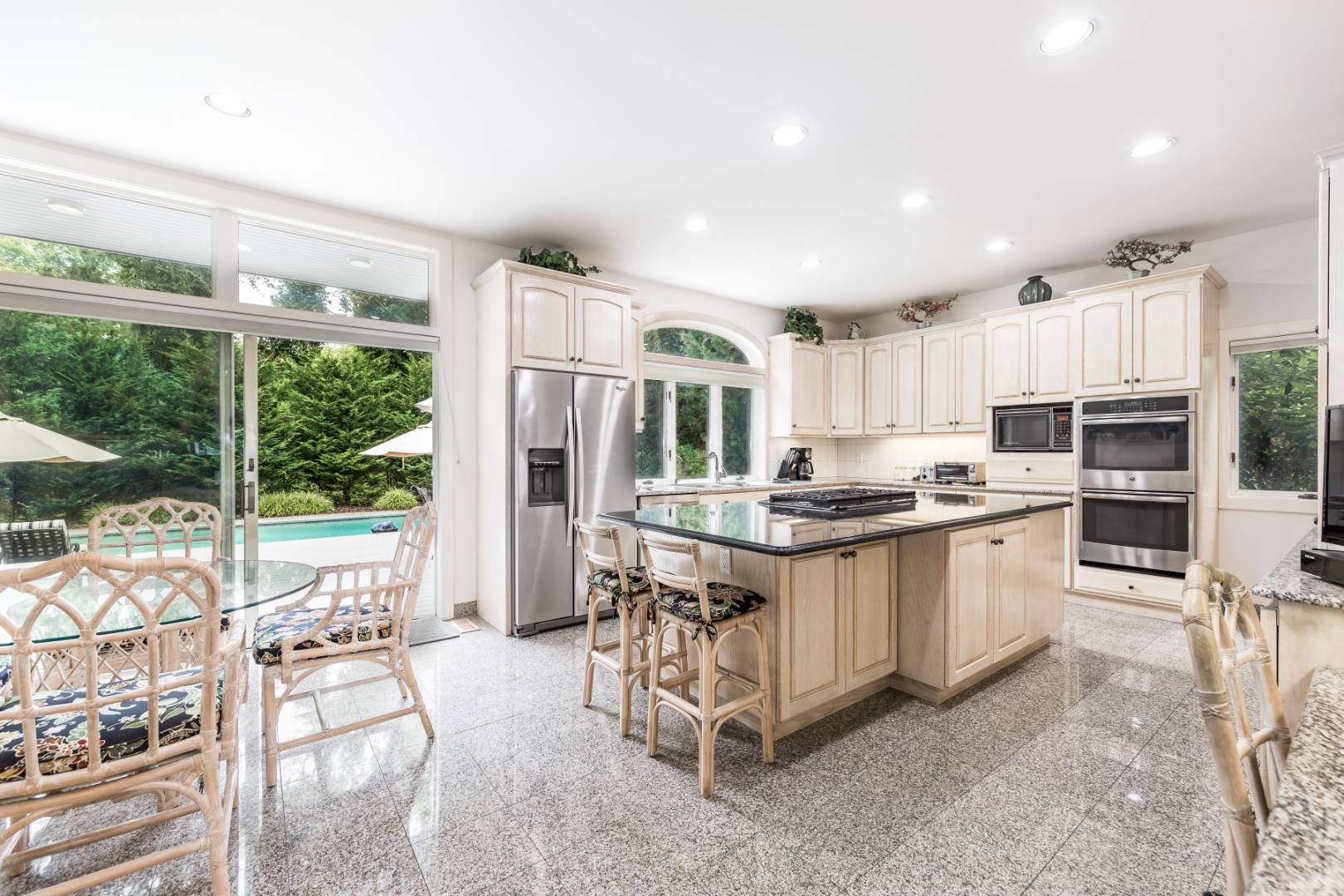 15 Atterbury Road Southampton, NY 11968 - Photo 10 of 20 a kitchen with stainless steel appliances granite countertop a stove oven and a refrigerator with white cabinets