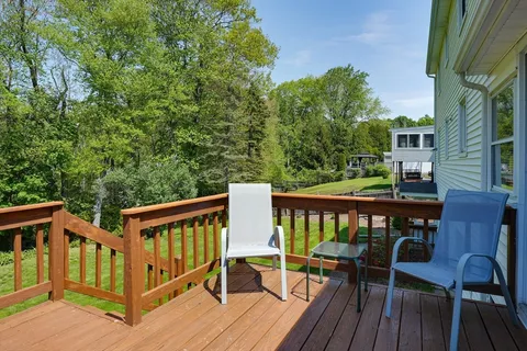 a view of a deck with two chair and wooden floor