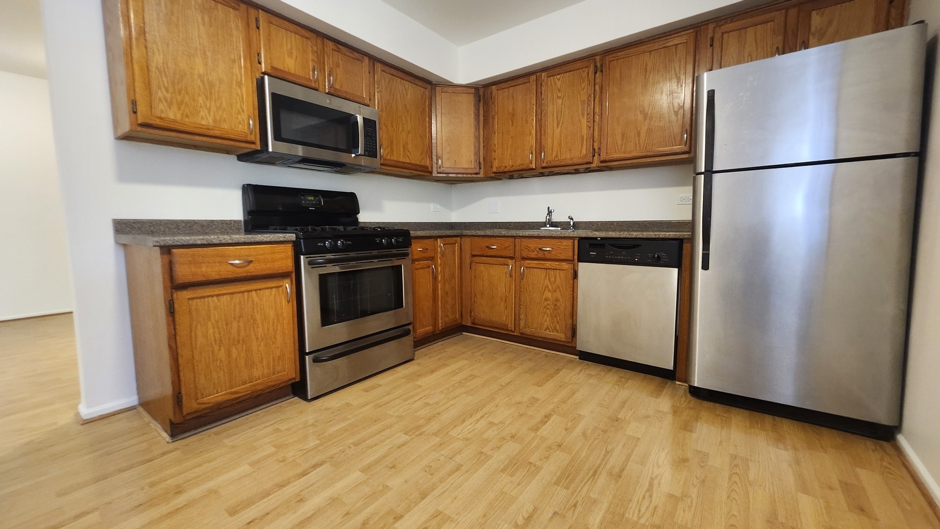 1450 Sandpebble Drive, Unit 333 Wheeling, IL 60090 - Photo 11 of 22 a kitchen with stainless steel appliances granite countertop a refrigerator stove a sink and a microwave