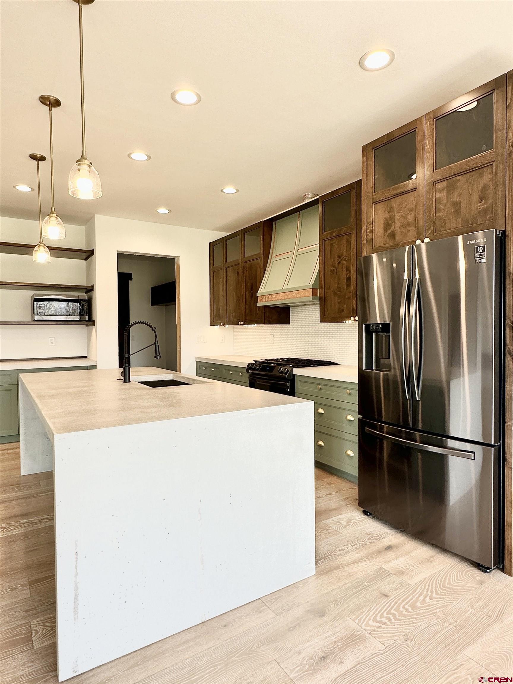 820 Southeast Pine Street Cedaredge, CO 81413 - Photo 11 of 35 a kitchen with stainless steel appliances kitchen island a refrigerator sink and cabinets