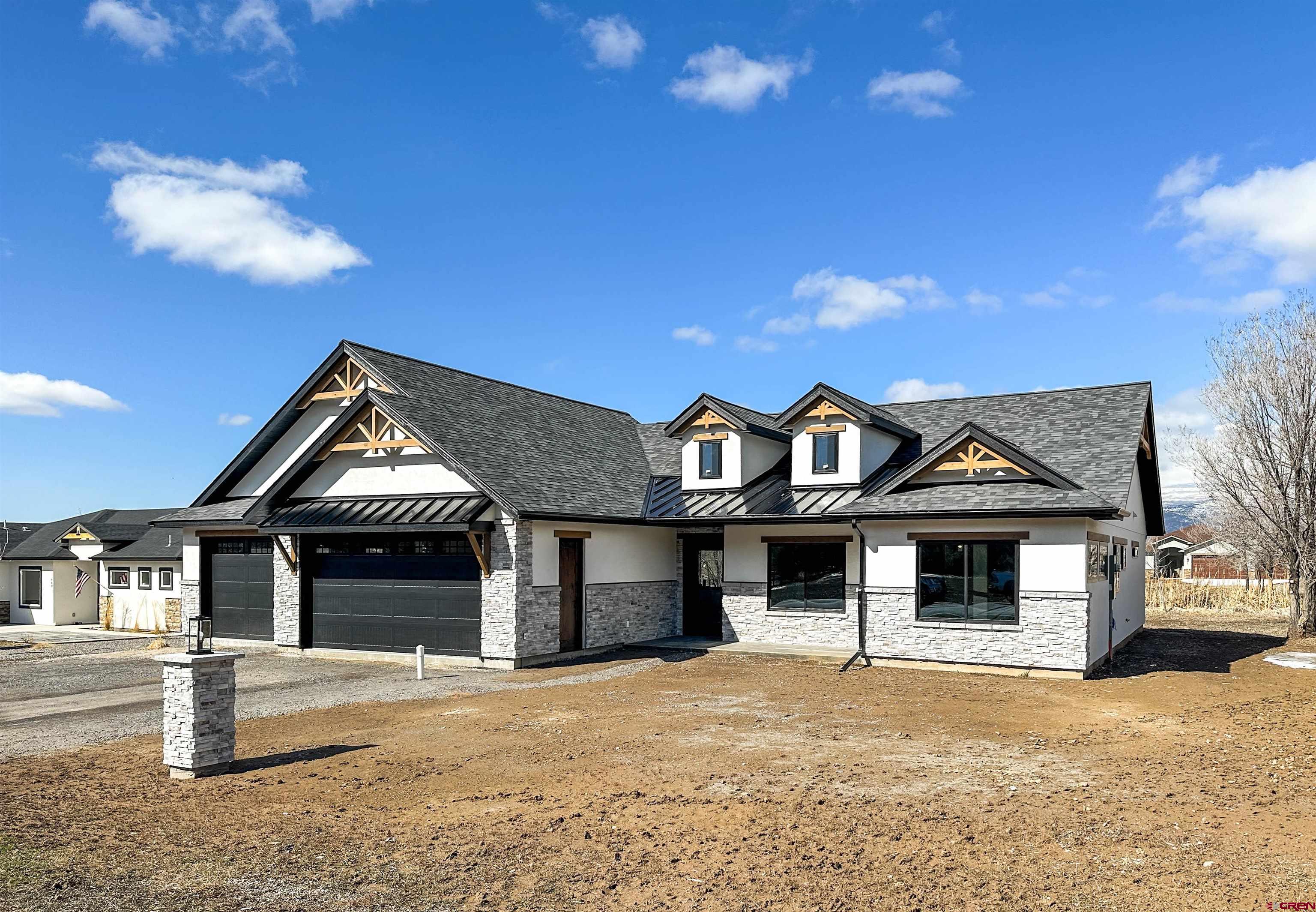 820 Southeast Pine Street Cedaredge, CO 81413 - Photo 2 of 35 a front view of a house with a yard and garage
