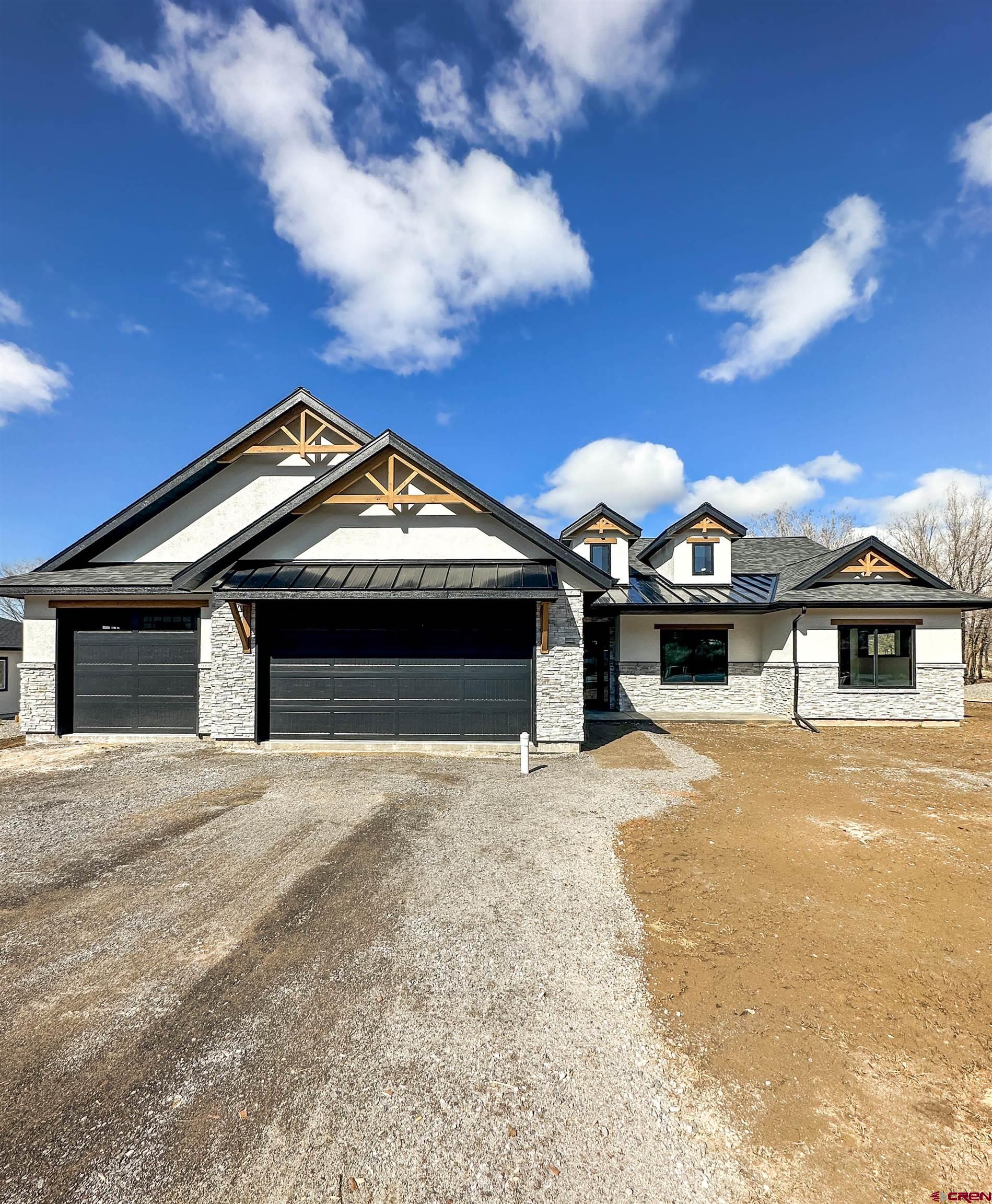 820 Southeast Pine Street Cedaredge, CO 81413 - Photo 3 of 35 a front view of a house with a yard and garage