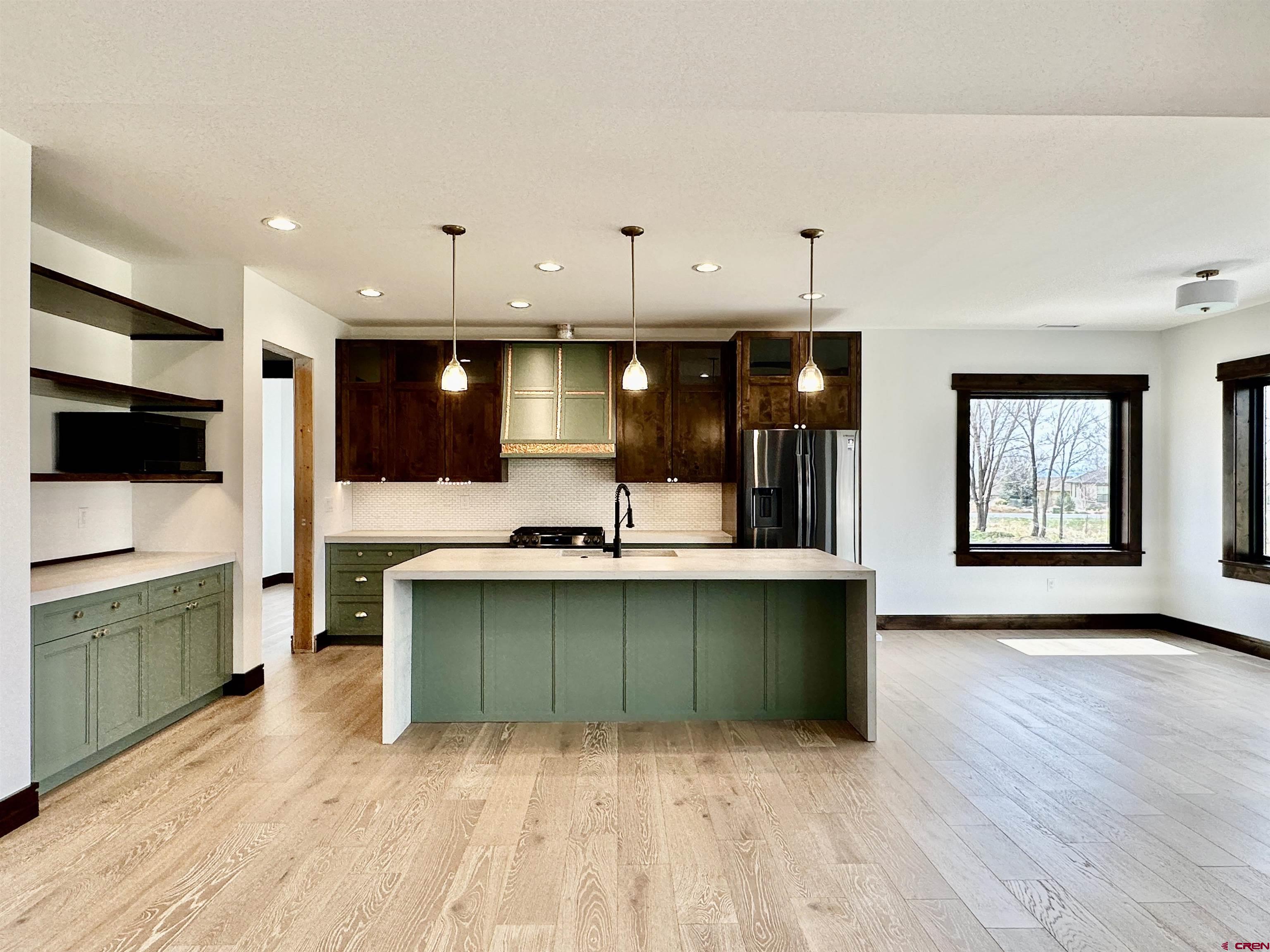820 Southeast Pine Street Cedaredge, CO 81413 - Photo 10 of 35 a view of a kitchen with kitchen island a sink wooden floor and stainless steel appliances