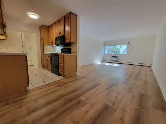 a view of kitchen with granite countertop cabinets and refrigerator