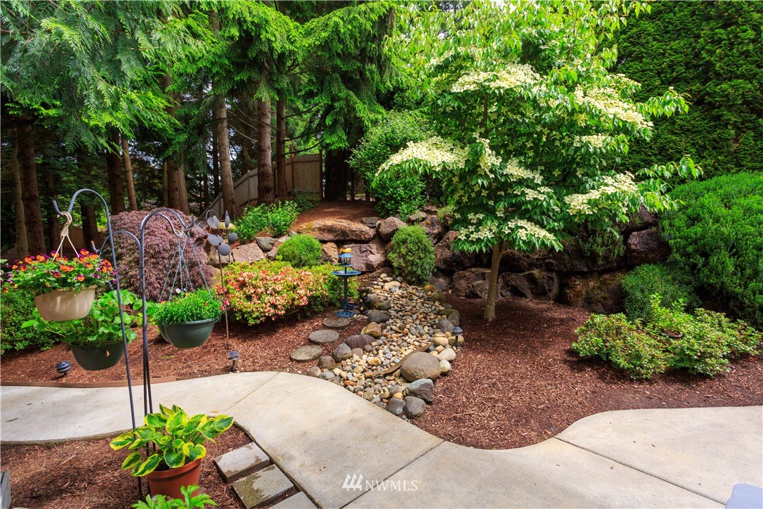 3205 211th Street Southeast Bothell, WA 98021 - Photo 34 of 40 a garden with lots of trees and flowers and covered with wooden fence