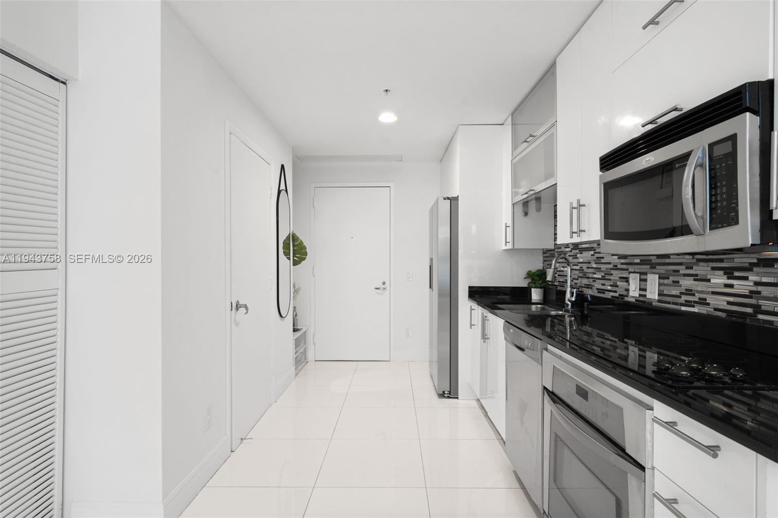 60 Southwest 13th Street, Unit 2812 Miami, FL 33130 - Photo 11 of 66 a kitchen with stainless steel appliances granite countertop a stove and a refrigerator