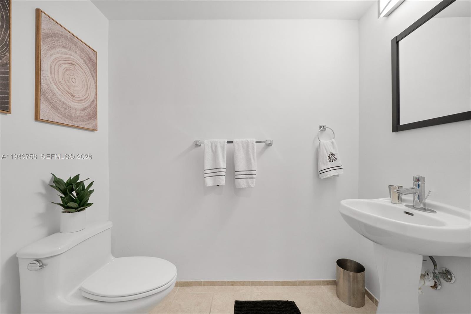 60 Southwest 13th Street, Unit 2812 Miami, FL 33130 - Photo 13 of 66 a bathroom with a sink a toilet and a mirror