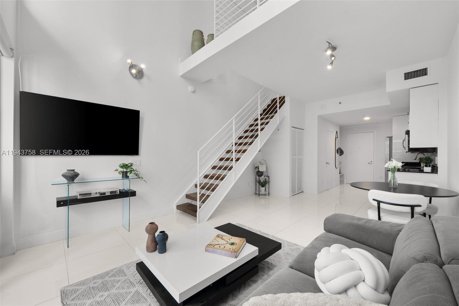 60 Southwest 13th Street, Unit 2812 Miami, FL 33130 - Photo 6 of 66 a living room with furniture and a flat screen tv