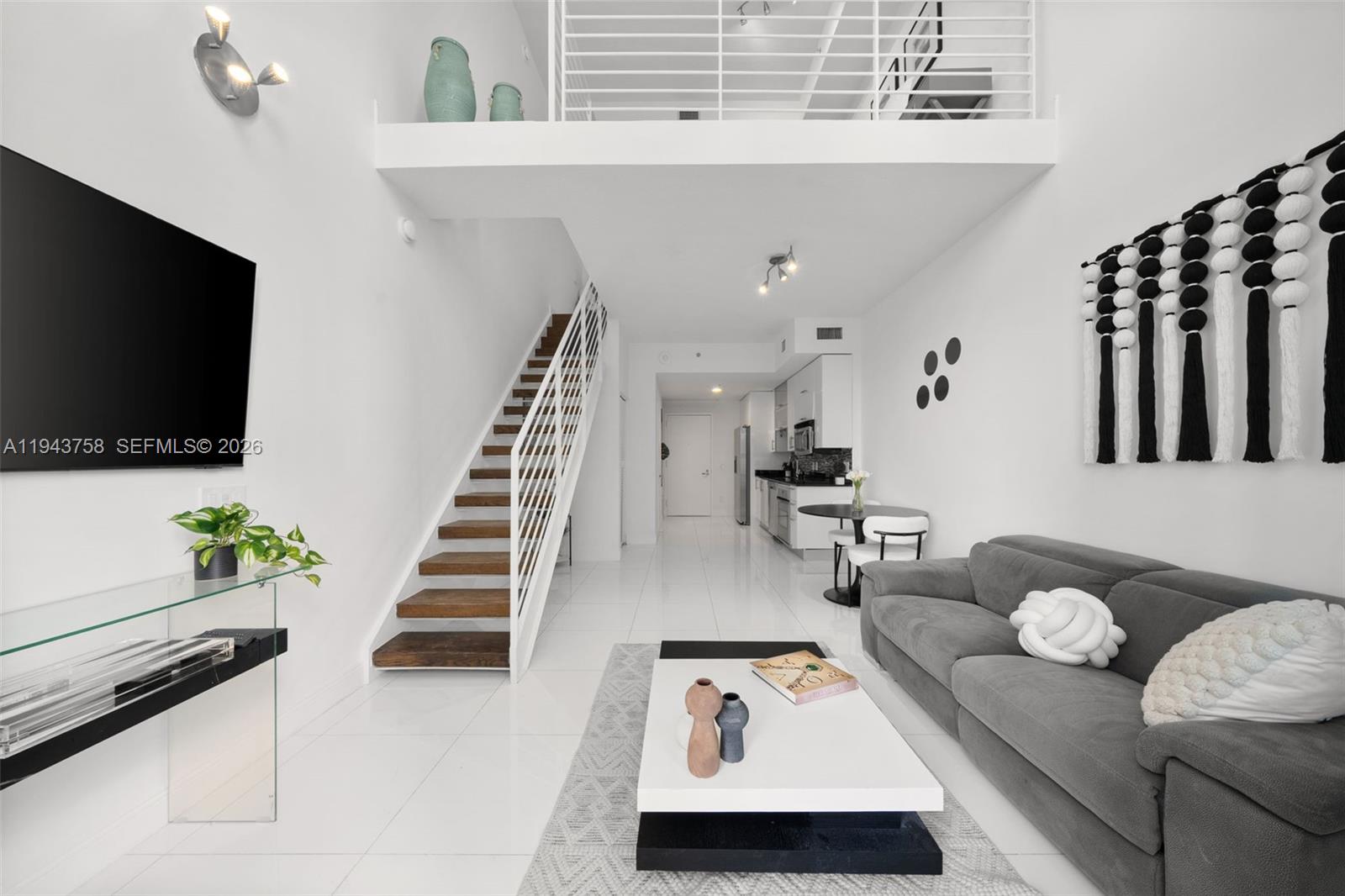 60 Southwest 13th Street, Unit 2812 Miami, FL 33130 - Photo 8 of 66 a living room with furniture and a flat screen tv