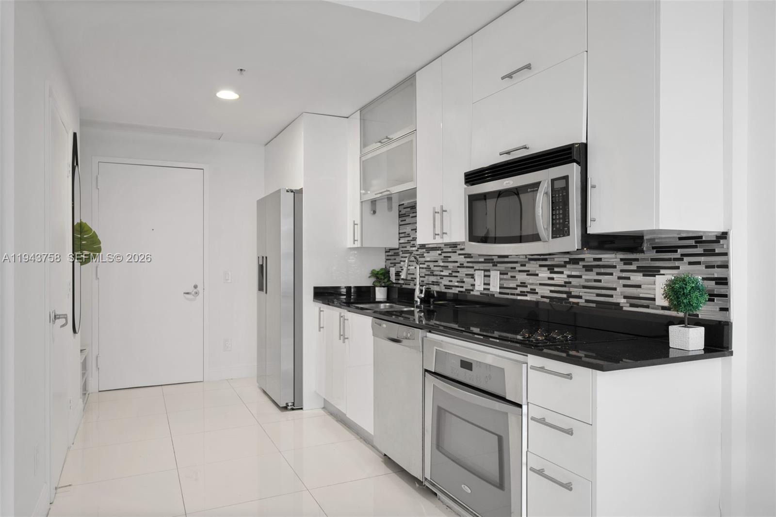 60 Southwest 13th Street, Unit 2812 Miami, FL 33130 - Photo 10 of 66 a kitchen with stainless steel appliances kitchen island granite countertop a refrigerator and a stove top oven