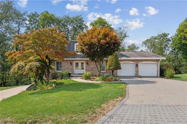 a front view of a house with a yard and trees