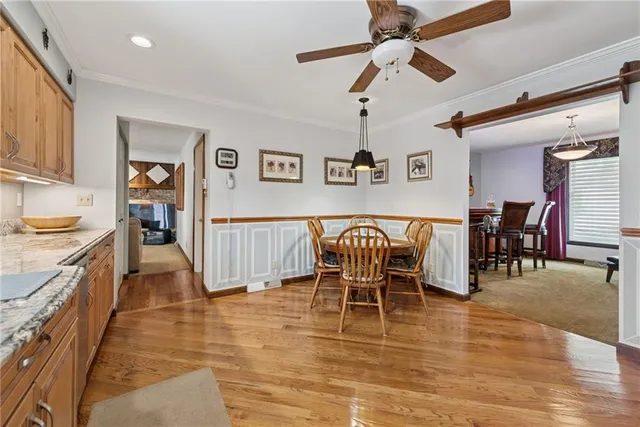 a dining room with furniture a chandelier and wooden floor