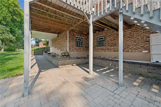 a view of a street with potted plants and large trees