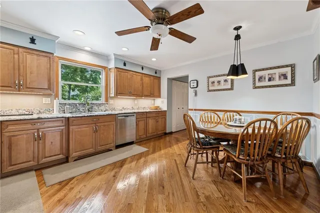 a kitchen with stainless steel appliances granite countertop a dining table chairs refrigerator sink and cabinets