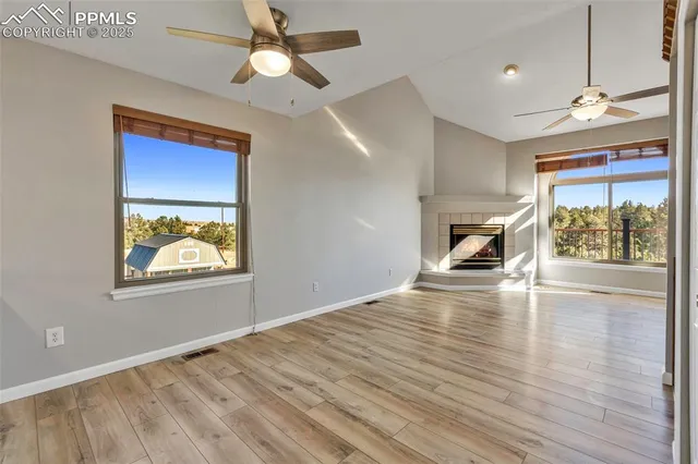 a view of a livingroom with wooden floor and a ceiling fan
