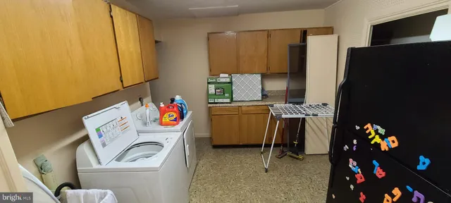 a utility room with fridge dryer and washer