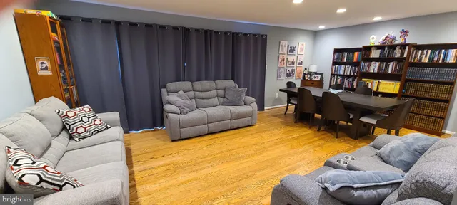 a living room with furniture a rug and a book shelf