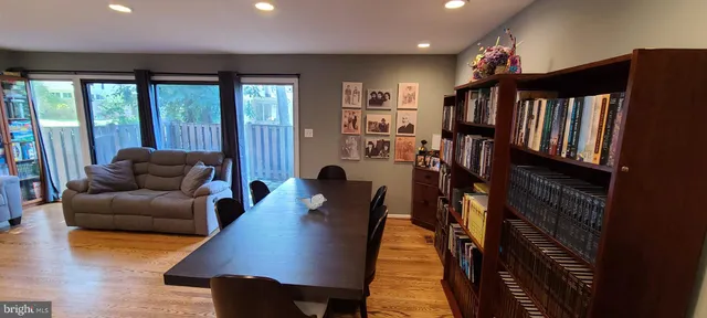 a living room with furniture a large window and wooden floor