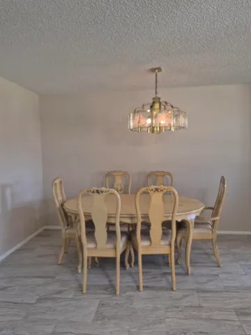 a view of a dining room with furniture and chandelier