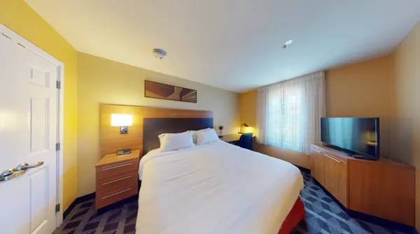 a bedroom with a bed and a flat screen tv