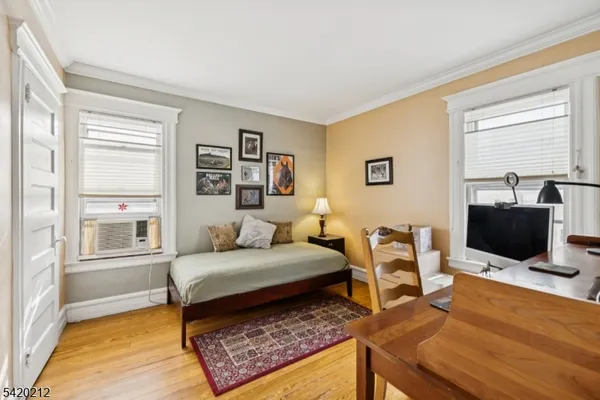 a bedroom with a bed a window and a flat screen television