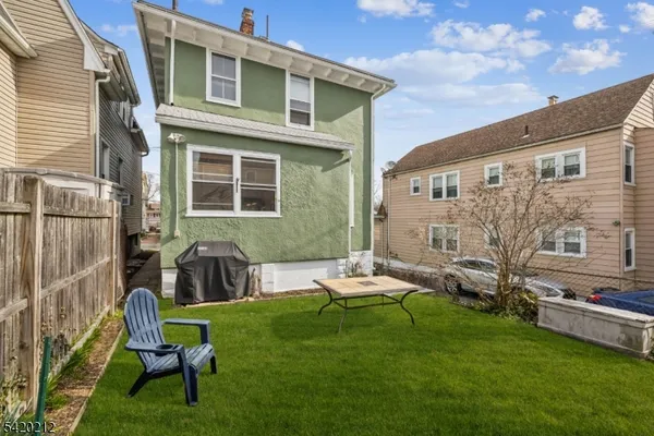a view of a chair and table in backyard of the house