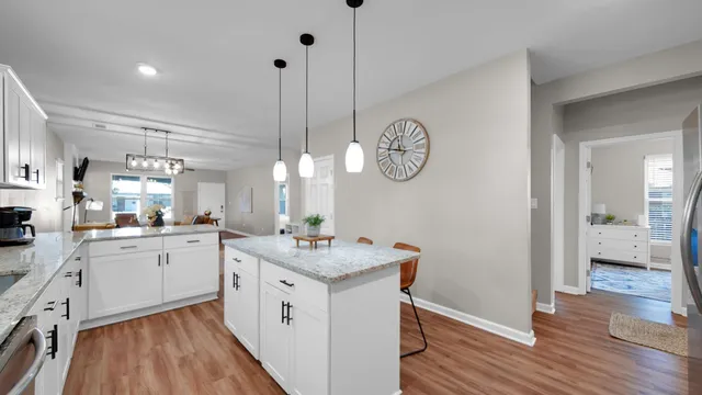 a kitchen with a sink dishwasher and wooden floor