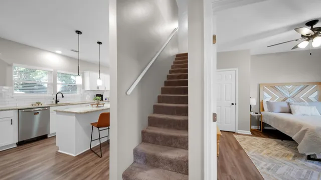 a open kitchen with stainless steel appliances granite countertop a stove a sink a dining table and chairs with wooden floor