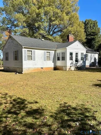 a front view of a house with a garden and tree