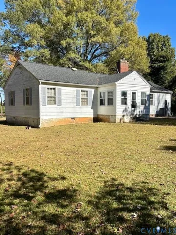 a front view of a house with a garden and tree