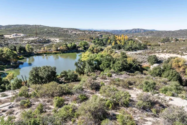 an aerial view of a house with a yard and lake view in back
