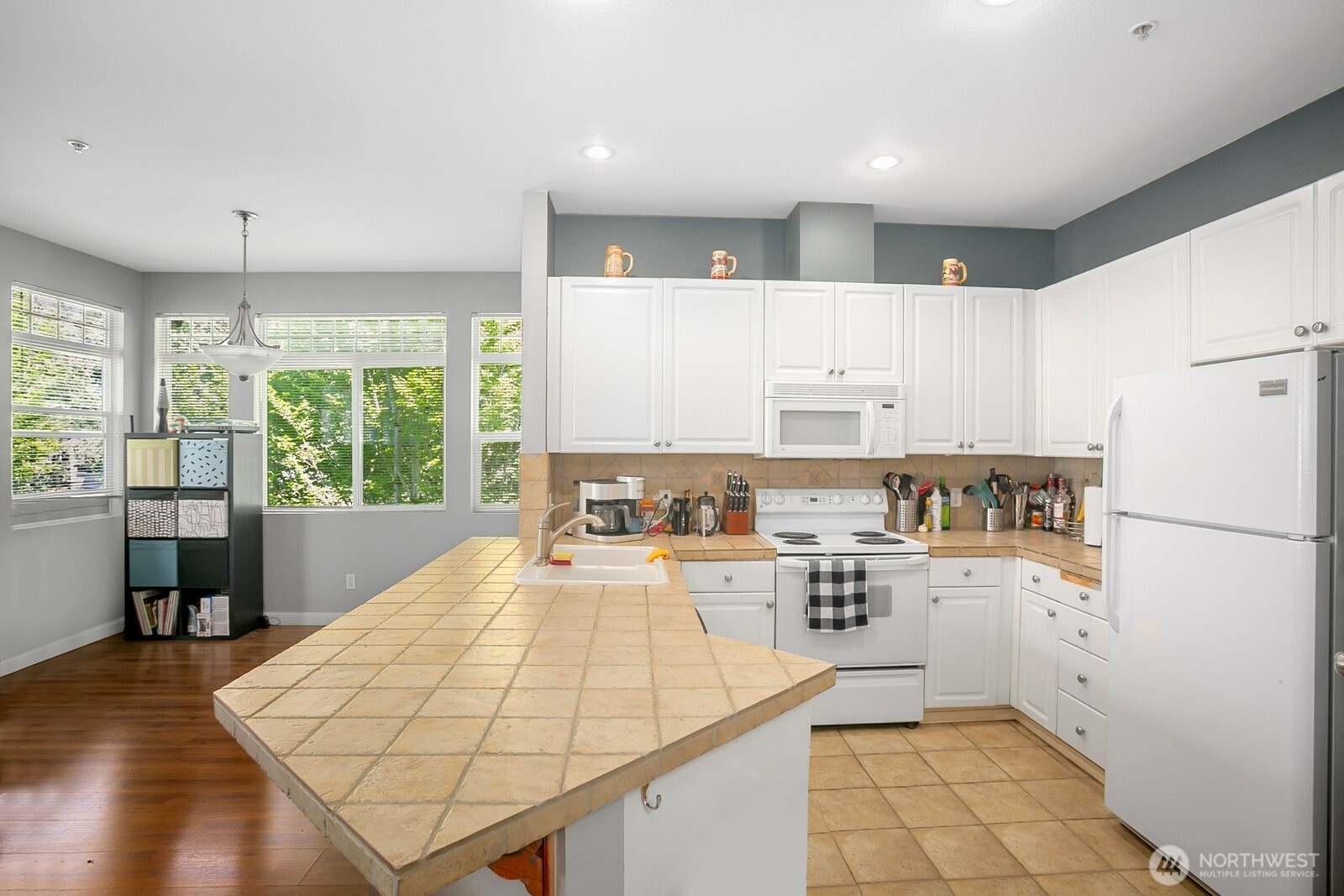 17614 134th Lane Southeast Renton, WA 98058 - Photo 6 of 16 a kitchen with stainless steel appliances granite countertop a refrigerator a sink dishwasher a stove with white cabinets and wooden floor