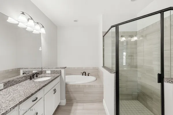 a bathroom with a granite countertop sink a mirror and shower