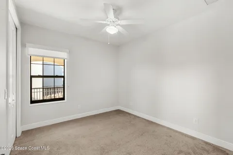 an empty room with closet and a ceiling fan